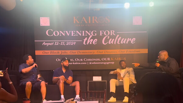 The image captures a panel discussion at the 2024 "Convening for the Culture". Four people are seated on a stage, engaged in conversation. The backdrop features a large banner with event details, including the dates August 12-15, 2024, and messages about Black jobs, democracy, and freedom.